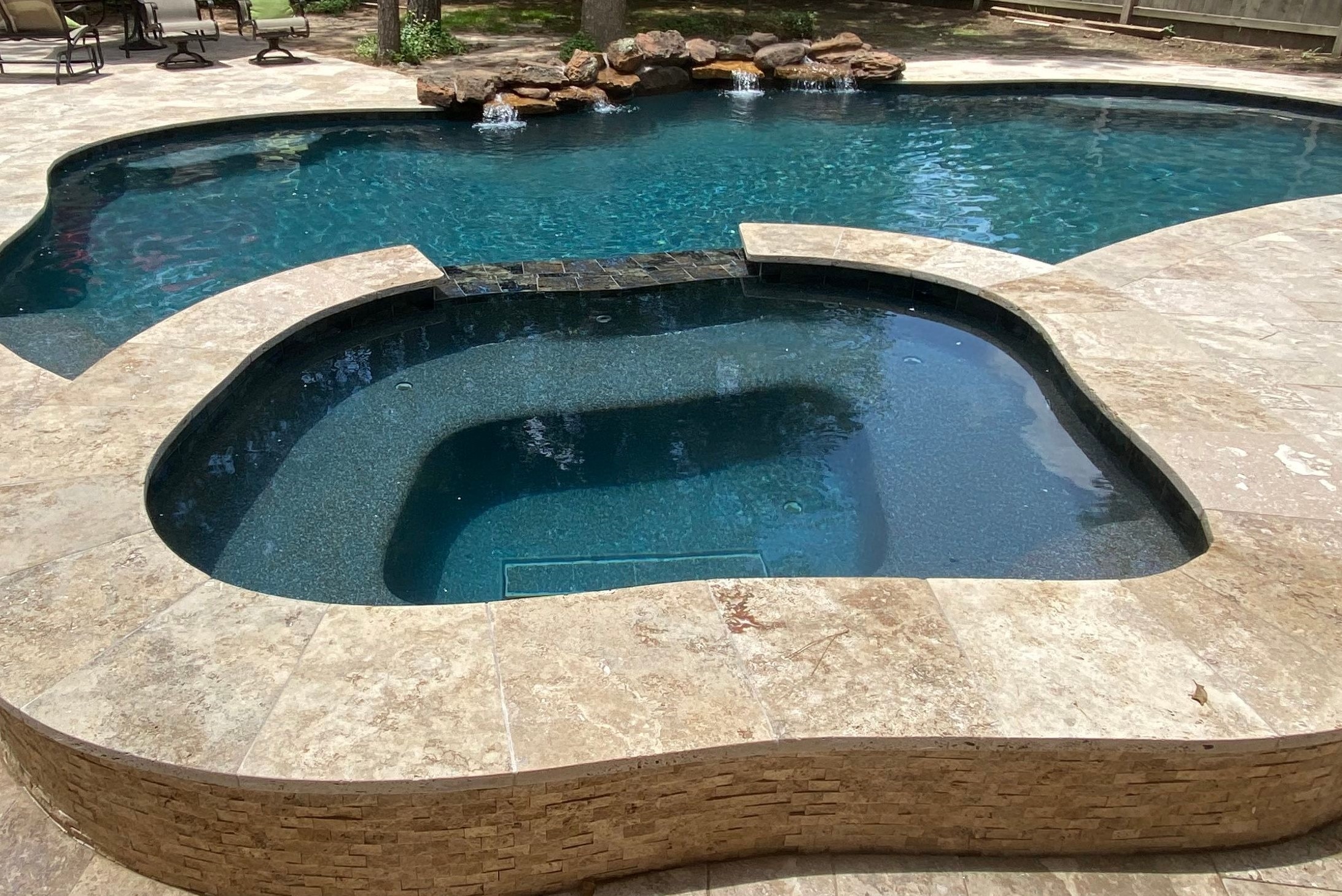 Custom pool and spa with travertine decking and split face