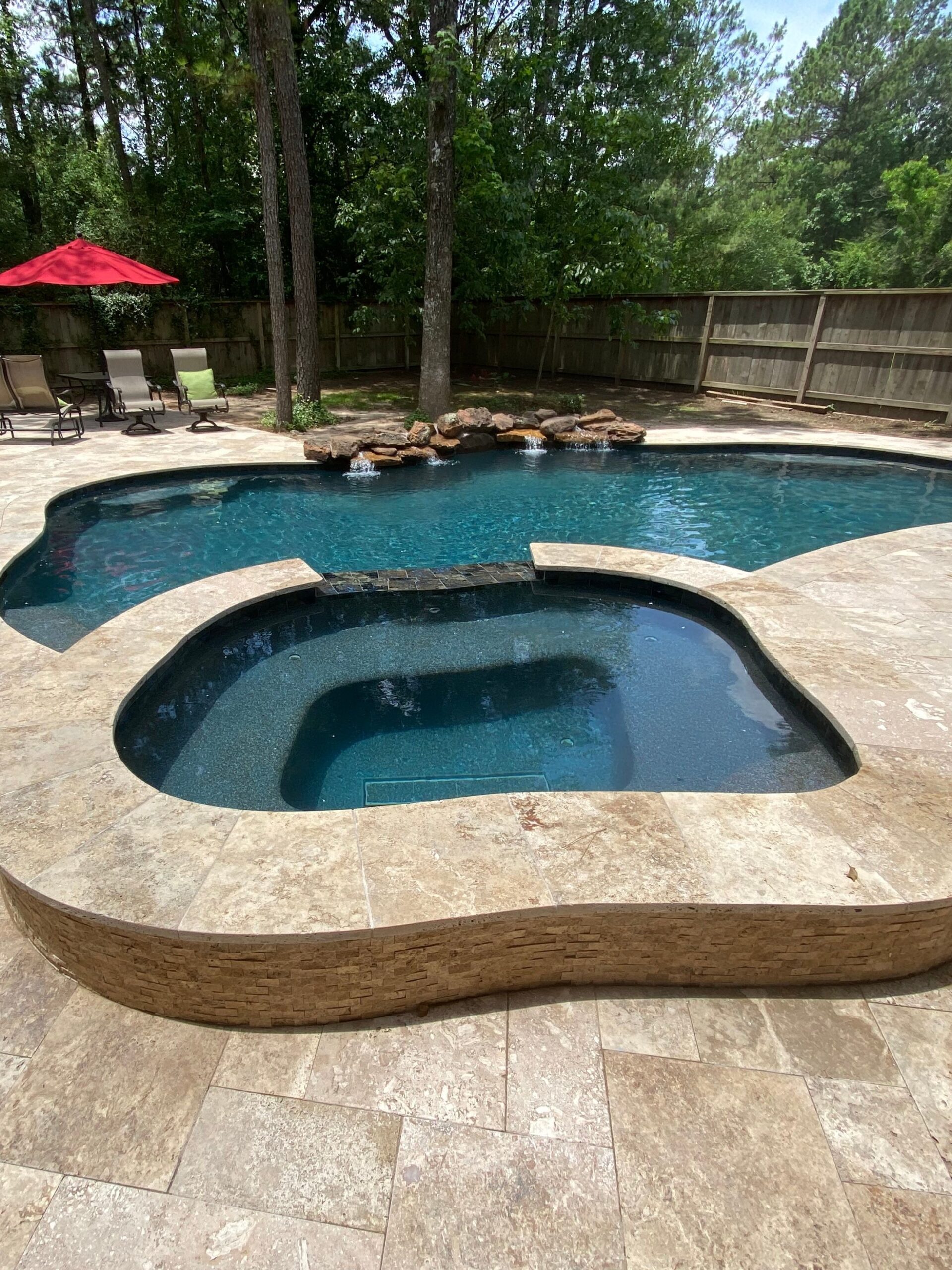 In-ground pool with attached spa and rock waterfall
